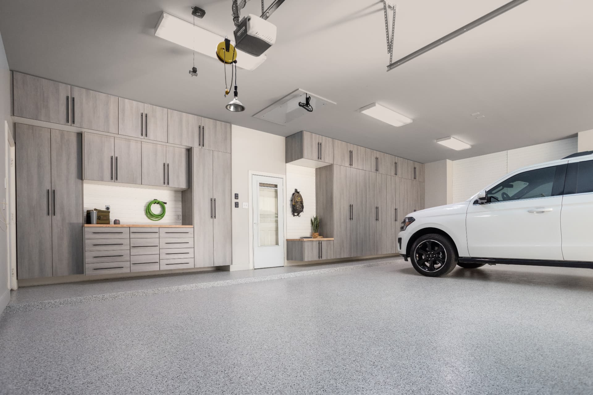 Completed GarageExperts of Portland garage with a Dakota Grey flake floor coating and custom cabinets